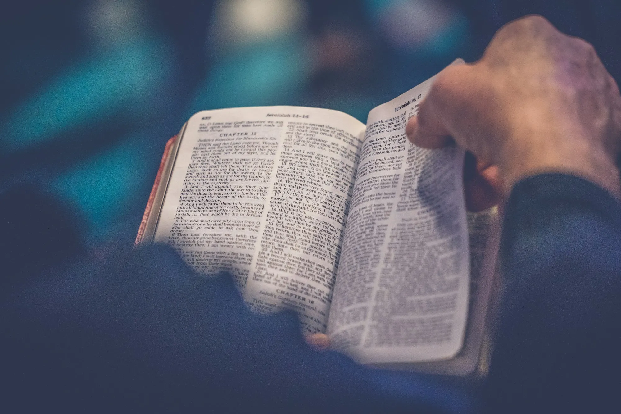 Mãos segurando uma Bíblia aberta durante a leitura