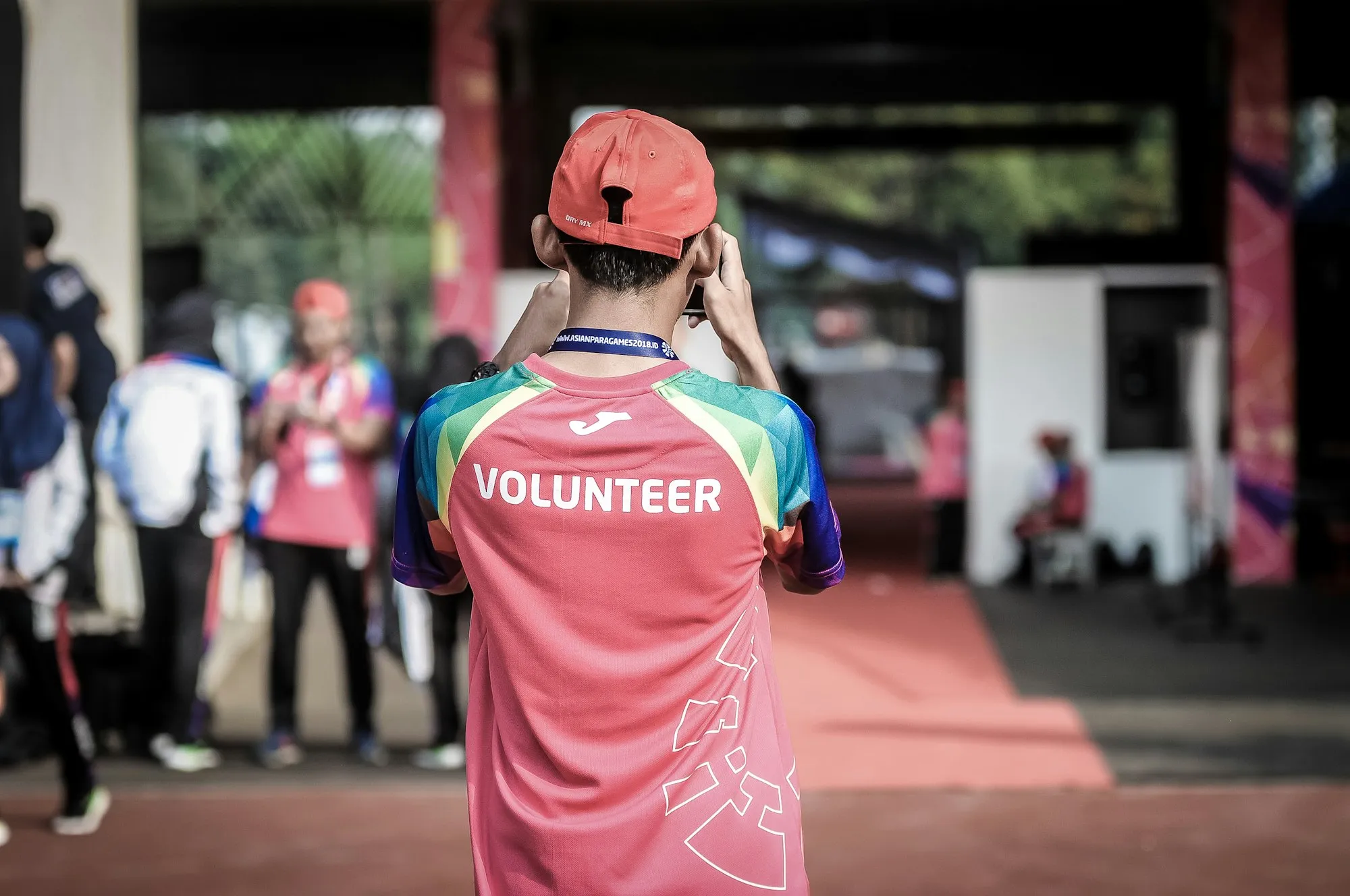 Voluntário de costas, usando camiseta com a palavra volunteer, em um evento